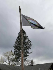 Nooksack Nation flag in front of cedar tree